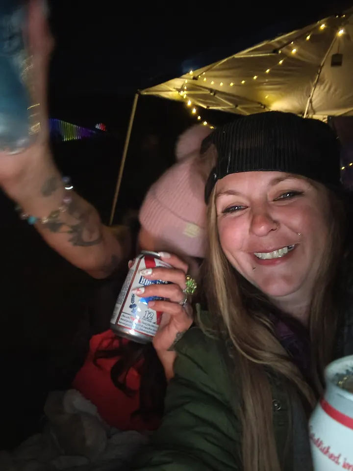 A smiling guest and a friend beneath the campsite’s string lights.