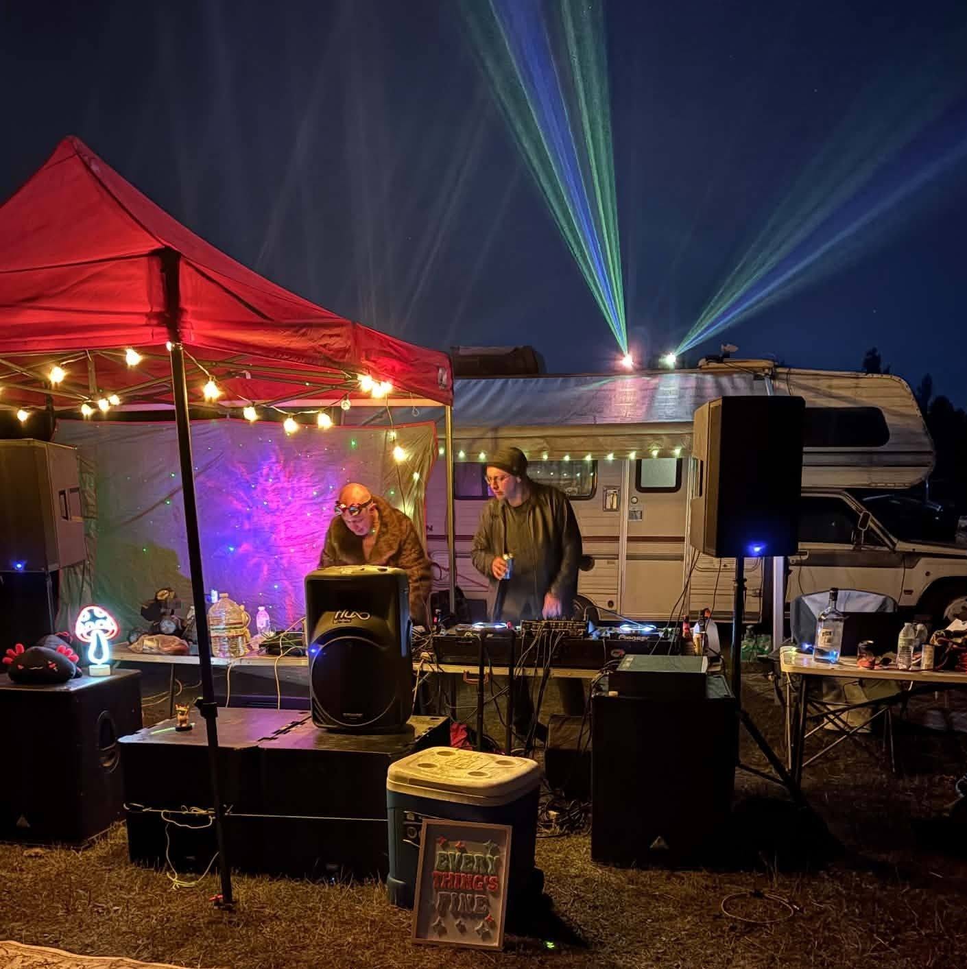 At the decks under the red canopy, with the camper and lasers behind us